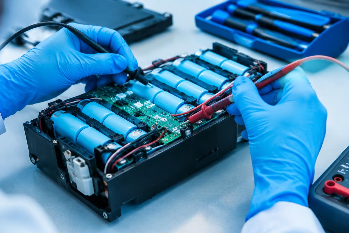 Technician testing an opened EV battery pack (illustrative image)
